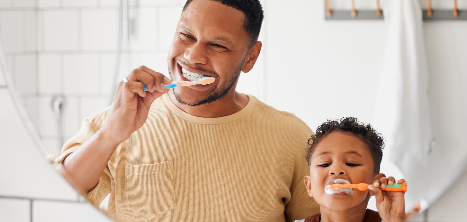 father and son brushing their teeth