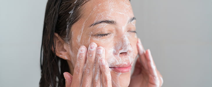 woman in shower using face soap