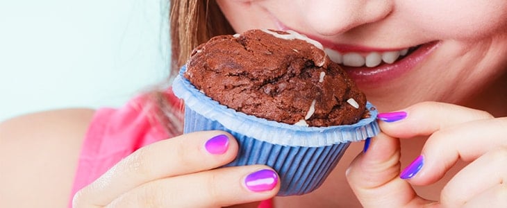 woman eating chocolate muffin