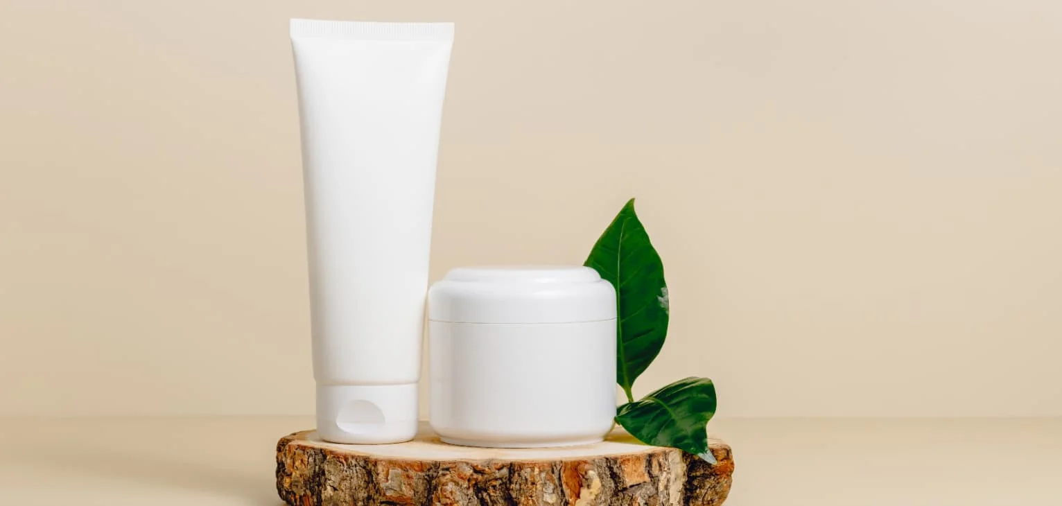 Cream tube and bottle on wooden podium