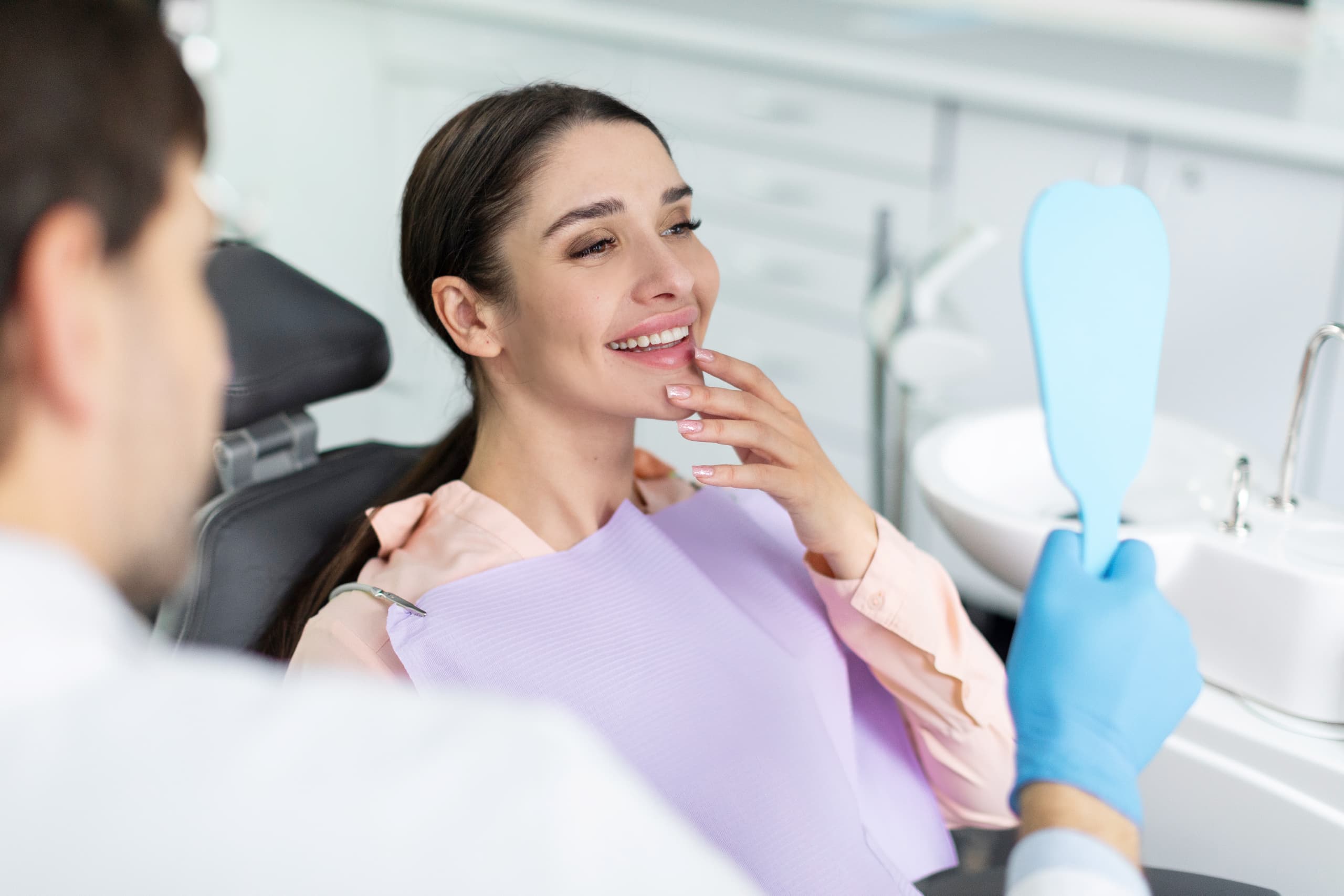 woman looking at teeth after whitening