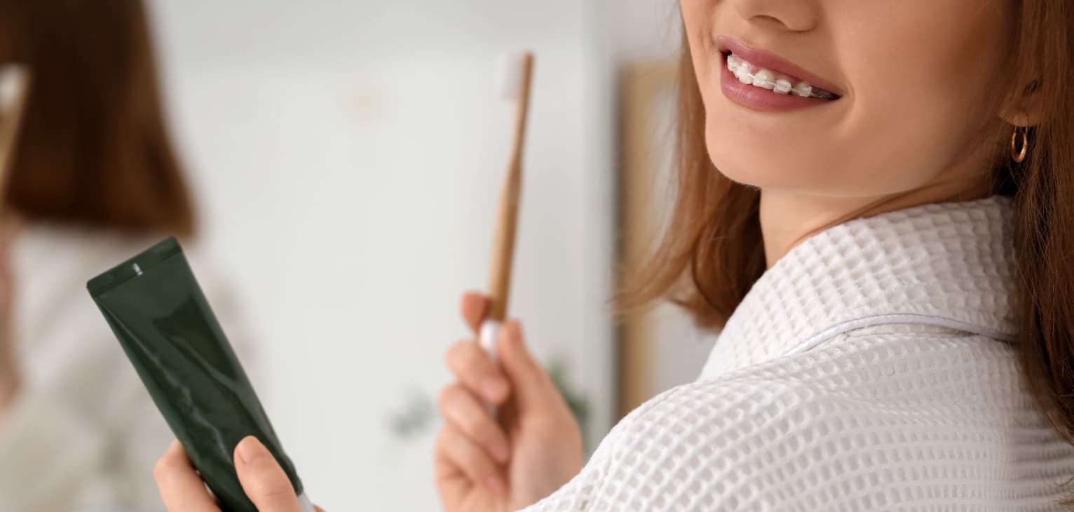 woman with braces brushing teeth