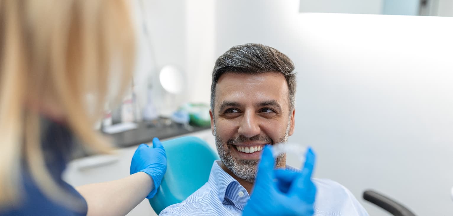 dentist showing man invisible adult braces